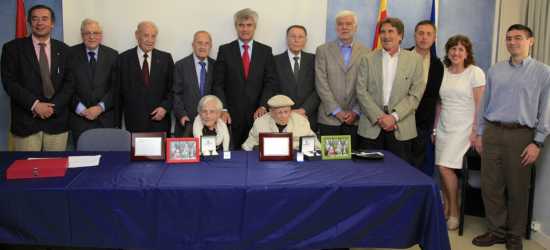 Josefina y José María, sentados, rodeados de compañeros y amigos